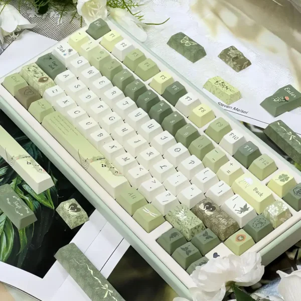 Quiet Depths 146-key keycap set in ivory, sage and moss green, shown on a keyboard