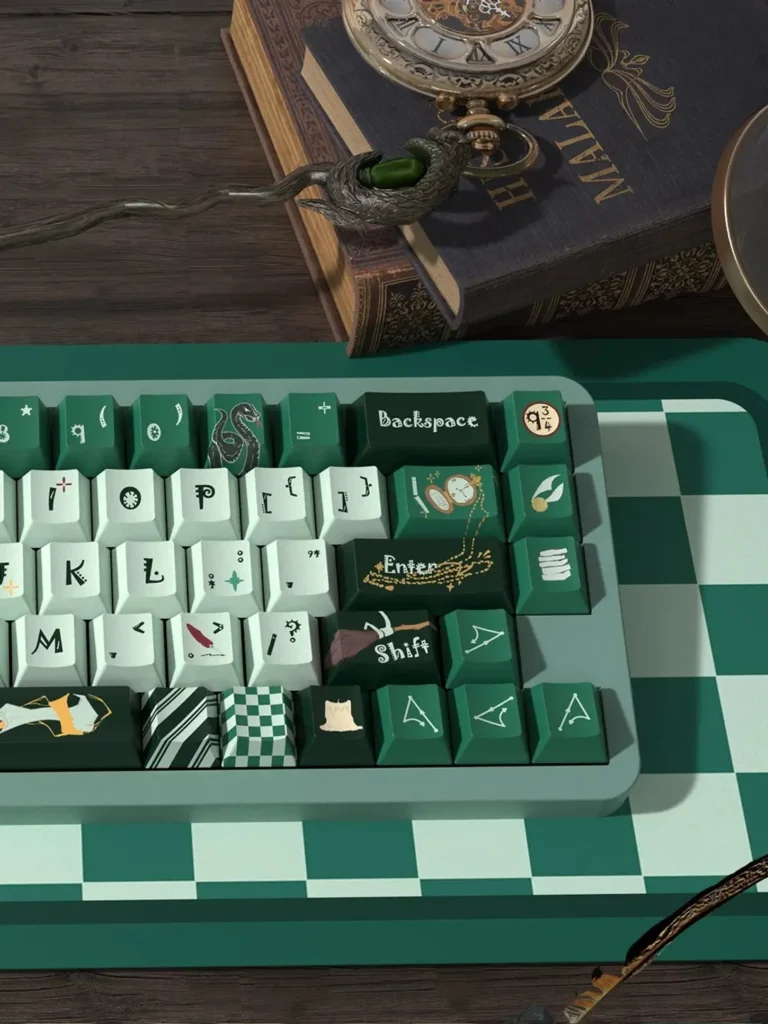 Right-side detail of Slytherin keycaps with snake, watch and wizarding novelty designs